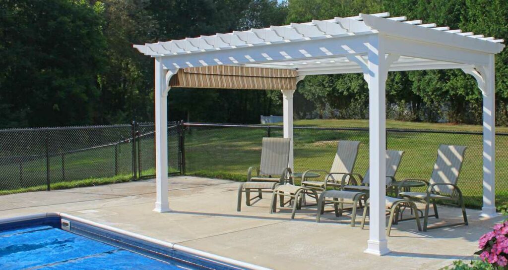 white pergola beside a pool with 4 chairs under it
