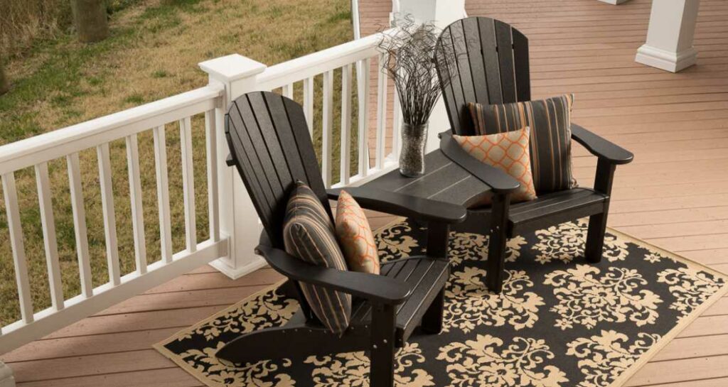two dark brown chairs sitting on a deck