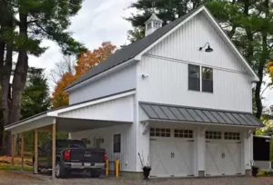 a white carriage house garage with a lean-to