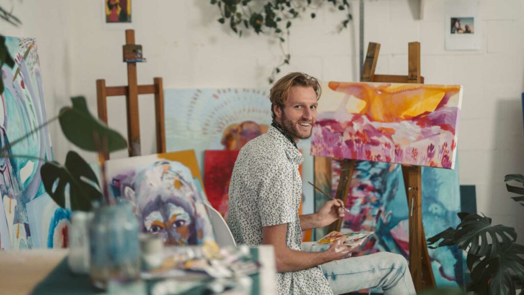A man painting in a studio shed
