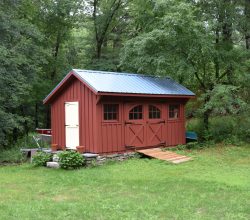 This 10x18 Shed is a red painted board & batten storage shed with blue metal roof.
