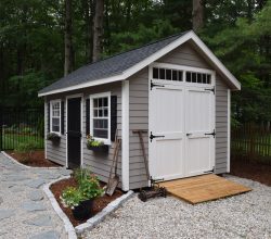 This 10x16 storage shed has vinyl siding and shingled roof with double doors and equipment ramp