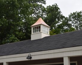 Vinyl cupola on commercial building with polished copper roof and widows.