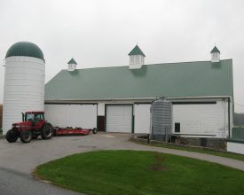 Barn cupola with green roof and white louvers.