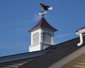 Cupola with copper top and decorative features and louvered panels plus a weathervane.