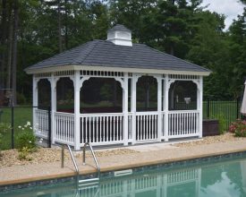 Rectangle vinyl gazebo featuring decorating spindles and fully screened with a cupola accent.