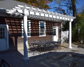 White vinyl attached to garage pergola, enhances the outdoor dining area.