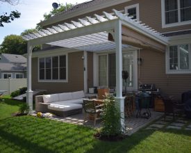Pergola attached to house with outdoor furniture plus features a EZ shade.