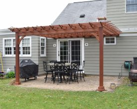 Stained cedar wood pergola attached to the house, adds value and style to any backyard.