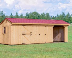 Horse barn featuring vertical cedar siding, red metal roof, with 2 stalls, and open storage/parking area.