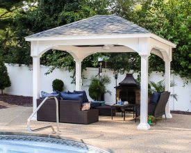This backyard pavilion has vinyl construction, built on the pool deck, and exposed rafter design,