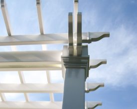 This pergola features white vinyl construction, special rafter tails, and vinyl wrapped columns.