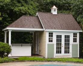 This poolhouse is personalized with multi color siding exterior, attached covered bar area, plus inside sitting area, with cupola accent.