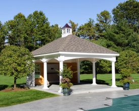 Pool House featuring white vinyl columns, shingled hip roof, and a cupola accent.