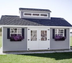 12x24 Storage shed featuring vinyl siding, double 9 lite door, shingle roof, custom cupola, and window boxes.