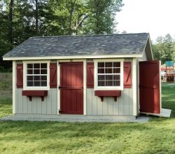 10x16 Shed featuring red painted doors with green siding, plus a ramp, and sits on crushed stone foundation.