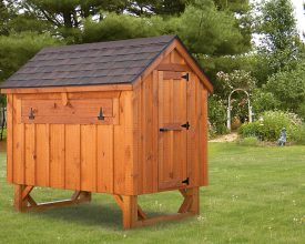 This chicken coop is built with stained cedar board exterior plus a shingle roof and is elevated off the ground for easy access.