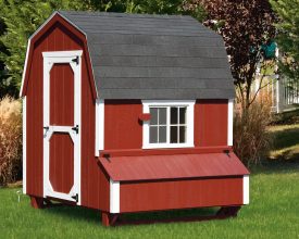 This barn style chicken coop is designed to look like a barn with its red paint and white trim and gambrel shingled roof.
