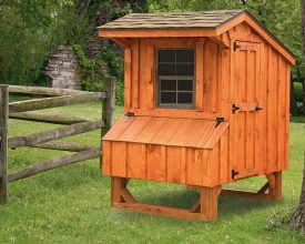 This small chicken coop has cedar board exterior, shingle roof, and nesting boxes.