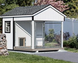 Dog Kennel with painted wood exterior, and shingle roof, and sits on crushed stone base.