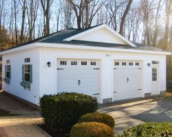 This custom 24 x 30 garage features white vinyl siding, hip roof, carriage house doors.
