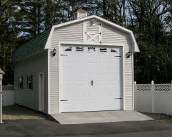 This personalized detached garage features, gambrel shingled roof, oversized garage door, & vinyl siding.
