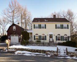 This custom garage features gambrel roof, upstairs loft storage, & custom windows.