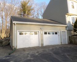 Personalized 26 x 28 garage features, vinyl siding, shingled gable roof, & guttering.