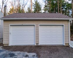 This detached 2 car garage includes vinyl shake siding, shingle roof, raised panel garage doors.