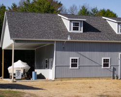 This awesome personalized garage features vertical painted siding, shingled roof with dormers, & lots of space.