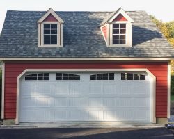 This awesome garage features, red Hardieboard siding, very wide full width garage door, & weathered wood shingle roof, with dormers.