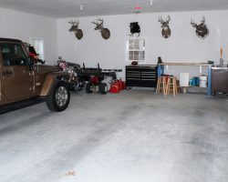 This custom 2-car garage features a fully finished interior, work area, & storage space.