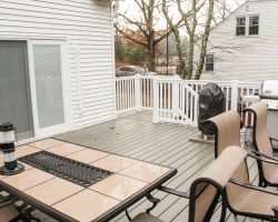 This custom built garage has a balcony area on roof attached to the house, with vinyl railing, and composite decking.