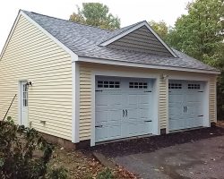 This custom 2 car garage features vinyl siding & shingle roof, with decorative dormer.