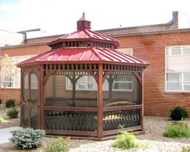 14' Baroque Style gazebo features octagonal shape with a metal roof, and is screened.