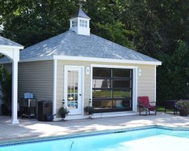 Pool house featuring a french door, glass design, hip roof, and a cupola.