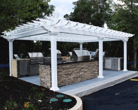 This white vinyl pergola completes this backyard kitchen area and is built with durable materials made to last a lifetime.