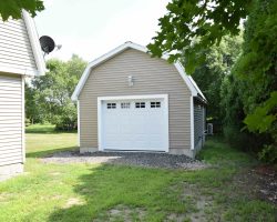 Custom 1 Car Garage with vinyl siding, gambrel roof, a garage bay door, and electrical!